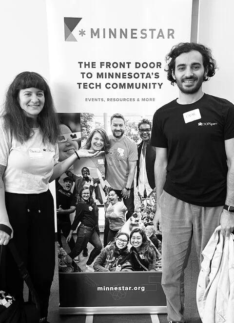 Daniella Attinella and Onar Alili, the founders of oopspam, wearing oopspam T-shirts at a Minnestar tech event